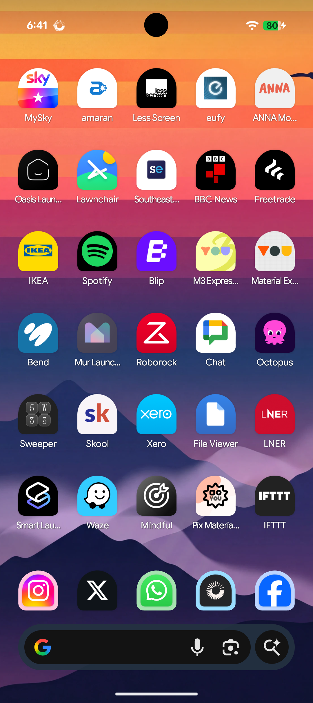 The phone with no mode: about forty colourful app icons on a sunset wallpaper.
